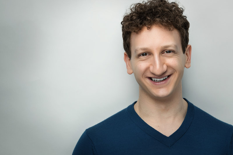 Craig Fogel smiling in a blue shirt on a white background